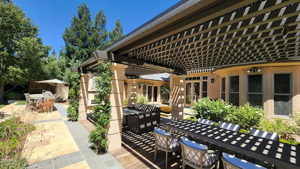 Photo of a home with a StruXure NorCal motorized pergola that provides cover for an outdoor dining area