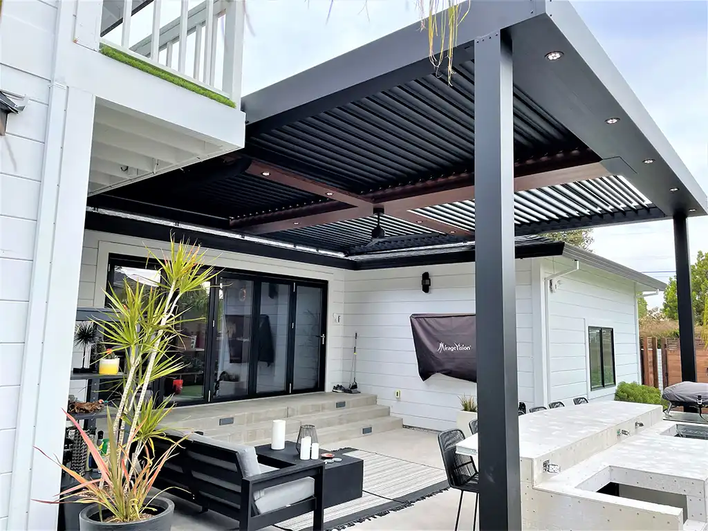 Photo of a StruXure electric pergola attached to the back of an establishment with an outdoor seating area and an outdoor bar and dining area.