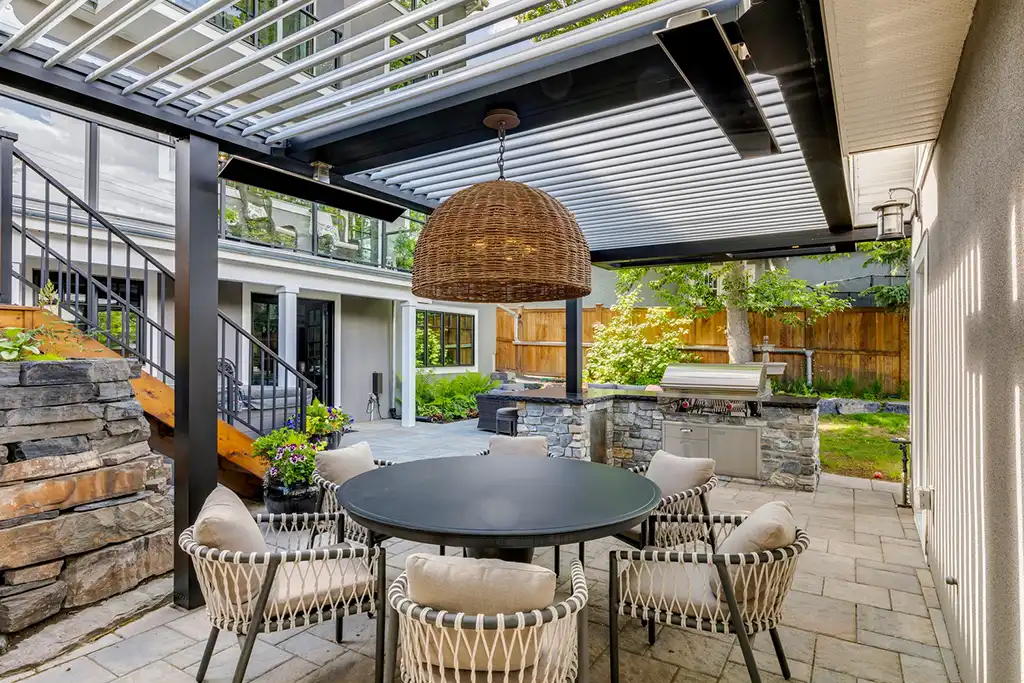 photo of a StruXure NorCal motorized pergola that provides shelter and shade for an outdoor dining room and outdoor kitchen attached to a home in Redwood City.
