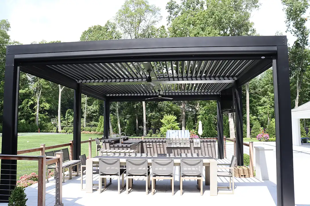 Photo of a StruXure louvered roof pergola within outdoor kitchen and dining area.