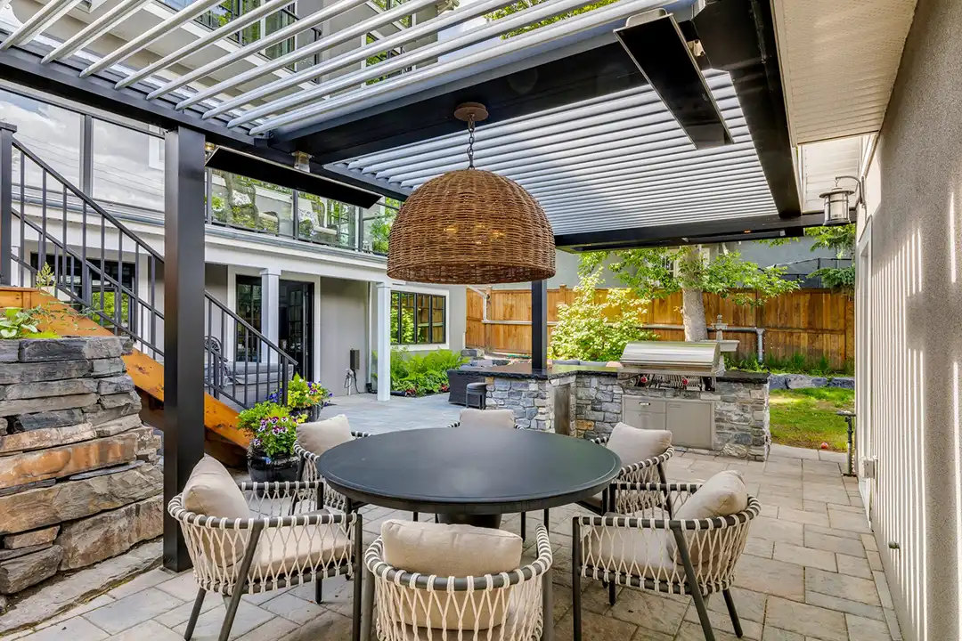 Photo of a StruXure pergola with louvered roof, outdoor kitchen, and outdoor dining area.