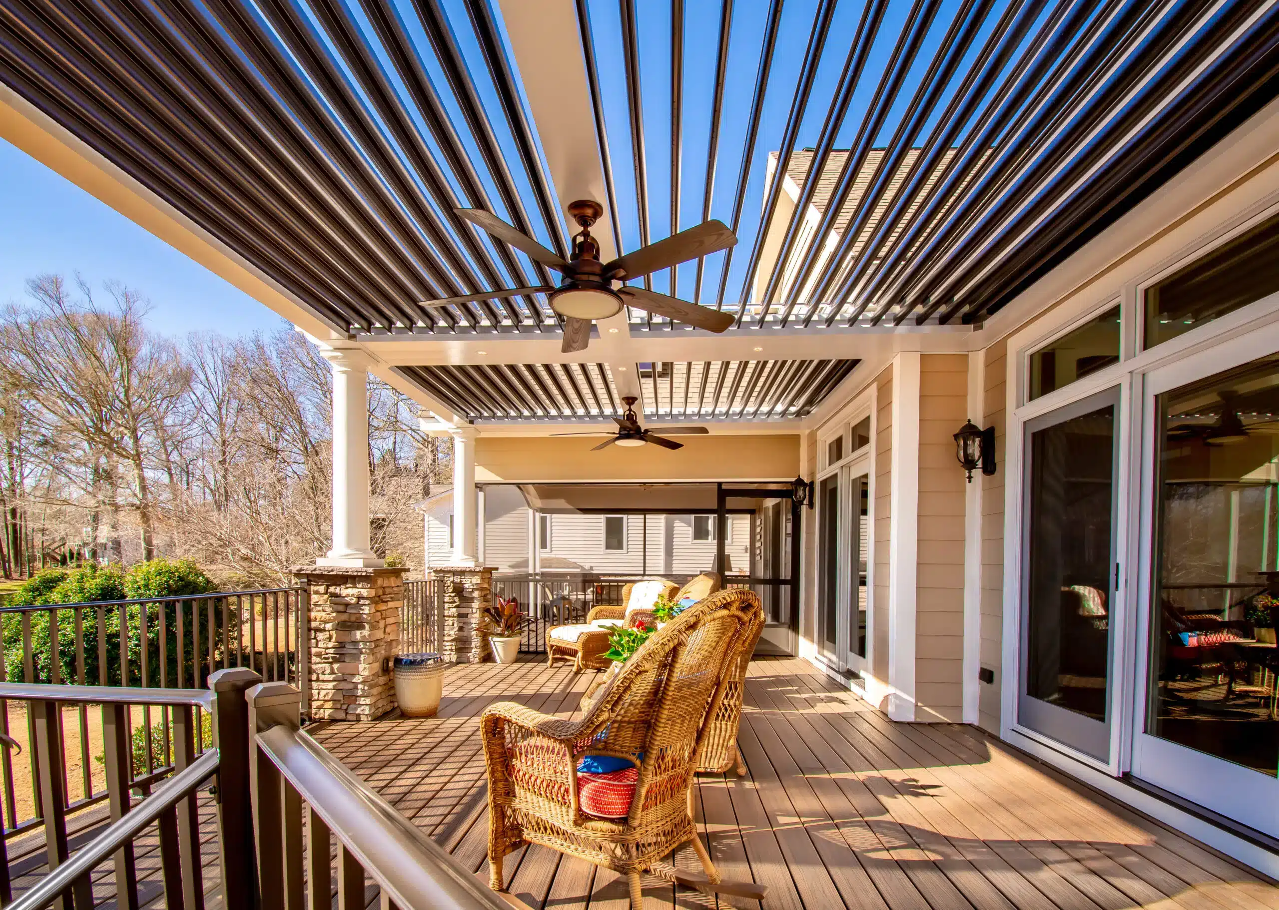 Louvered roof pergola over a deck with outdoor furniture