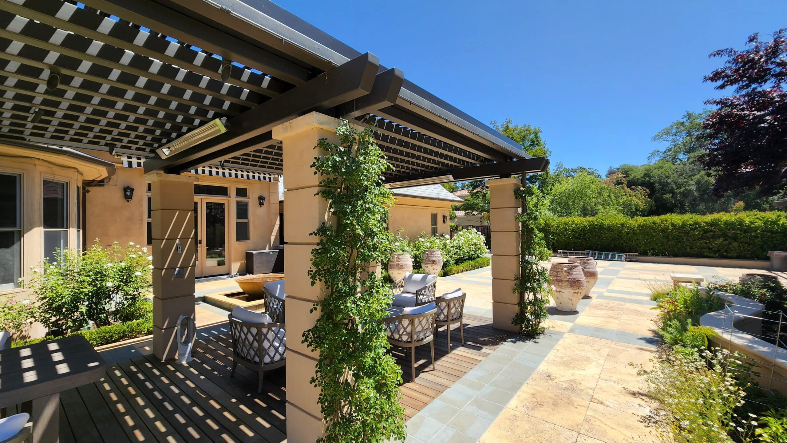 outdoor pergola with climbing plants and outdoor furniture - Benefits of StruXure Motorized Pergolas - Pergolas Builder and Contractor