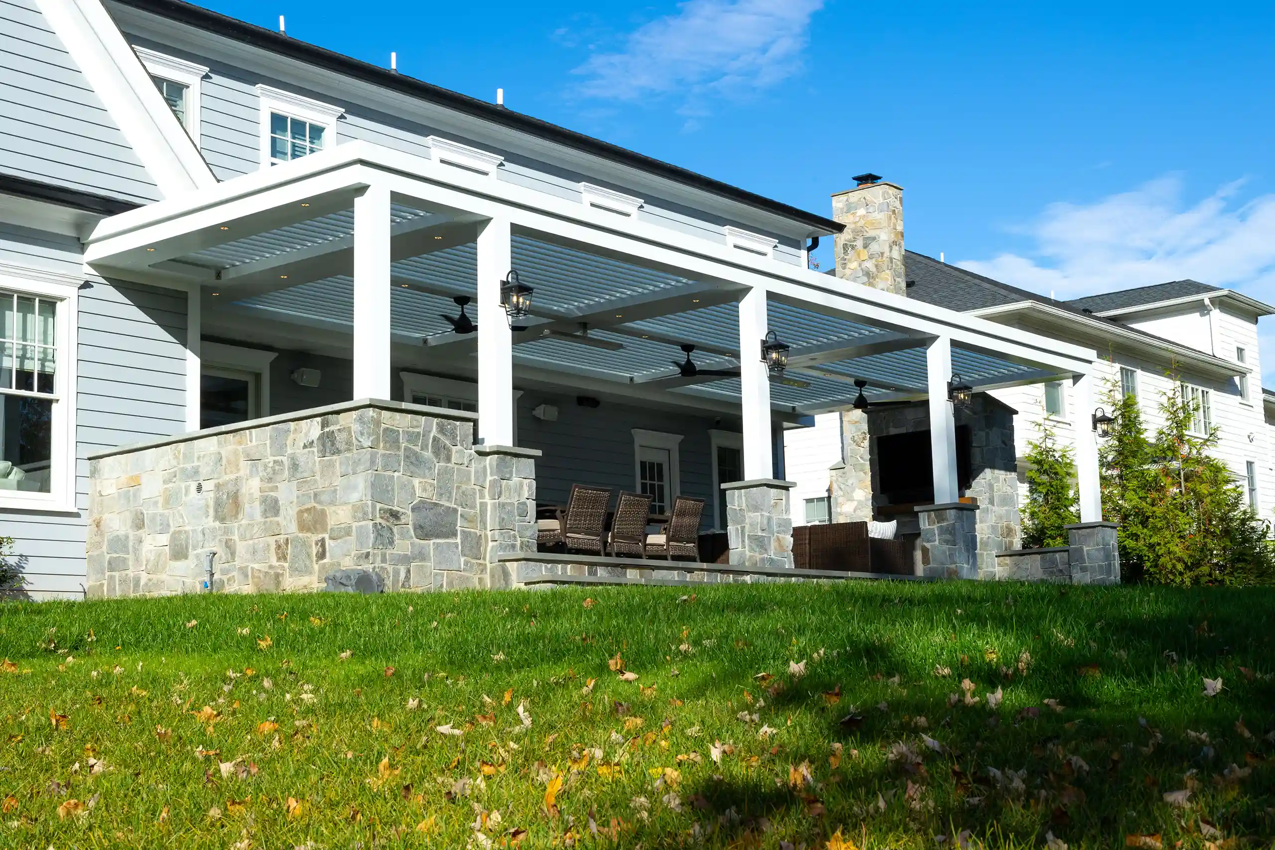 Photo of a StruXure pergola providing cover for a back patio entertainment area with ceiling fans and lights